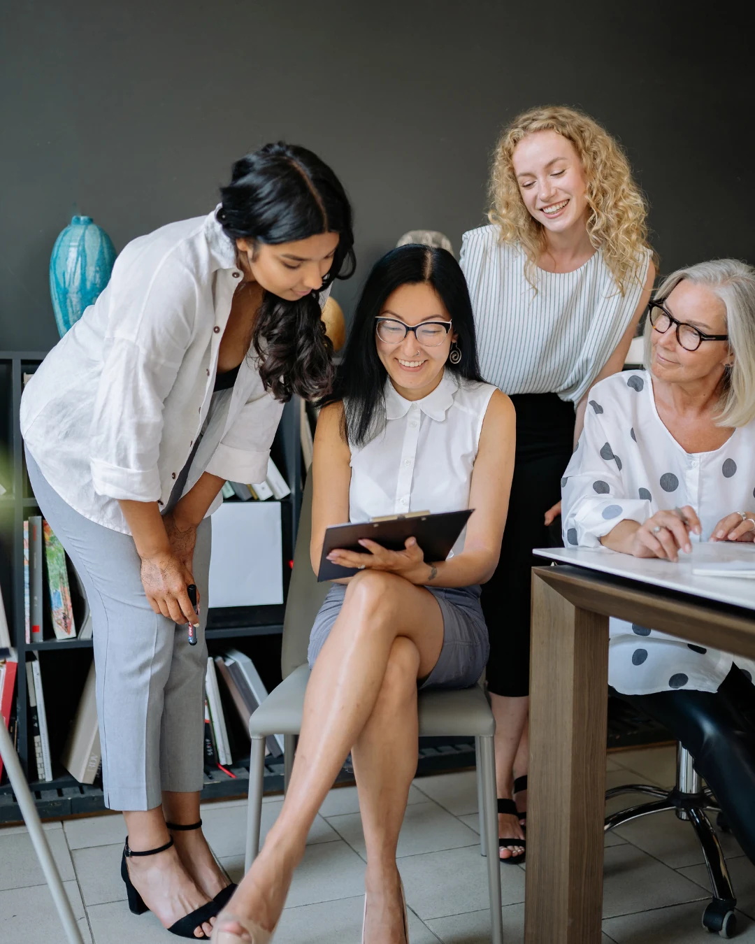 Women collaborating around a shared piece of work